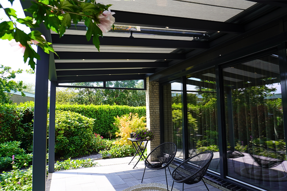 een overkapping met verandazonwering en spiekkozijnen in berkenwoude 3
